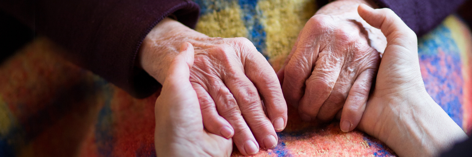 Due mani che si tengono, una delle due appartengono a una persona anziana