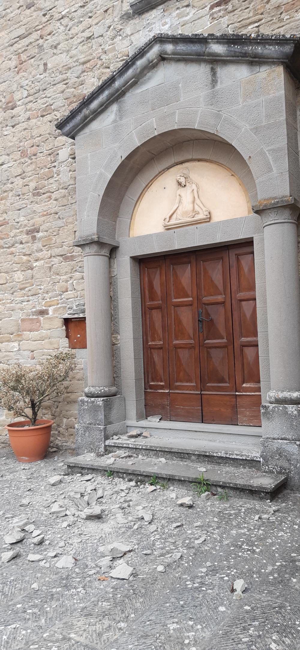 Caduta di uno stemma in pietra serena davanti all'ingresso di una chiesa nel comune di Marradi